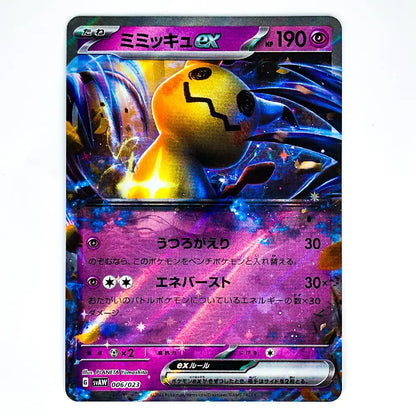 A holographic Pokémon trading card featuring Mimikyu ex, with a purple and blue cosmic design and a yellow Mimikyu character illustration, photographed on a white background.