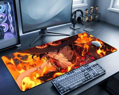 Gaming desk setup with a large mouse pad featuring an anime character on fire.