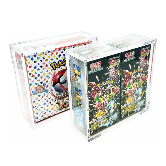 Two clear acrylic display boxes containing Pokémon TCG booster packs, shown on a plain white background. One box contains a white pack with multicolored character graphics, and the other contains black booster packs with colorful character art.