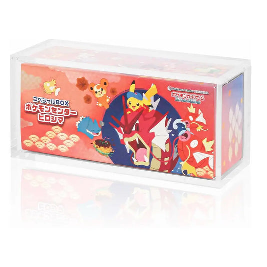 A clear plastic display box containing a red Pokémon-themed product package with Japanese text and illustrated characters, shown on a white background with a faint reflection.