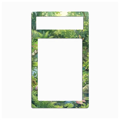 A rectangular decorative frame or magnet with a lush green forest and pond illustration border, featuring two white cutout slots at the top, shown on a plain white background.