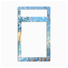 A rectangular decorative frame or mat with rounded corners, featuring a winter forest illustration in shades of blue, white, and soft brown. The design includes snow-covered branches, falling snow, and a warm light on the left side, with two horizontal white cutout slots near the top.