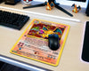 Retro Charizard Pokémon card themed gaming mouse pad displayed on a clean RGB gaming desk with mechanical keyboard and Charizard figurines