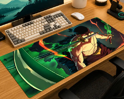 A large rectangular gaming desk mat with a colorful anime-style warrior illustration, shown on a wooden desk next to a keyboard, mouse, and monitor.