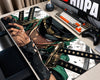 A large desk mat featuring an anime character illustration with a katana, styled on a desk next to a keyboard, controller, and monitor.