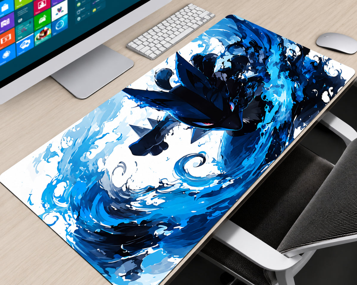 A large desk mat featuring a dynamic blue and black wave illustration with a dark bird-like creature, shown on a light wood desk next to a computer monitor, keyboard, mouse, and chair.