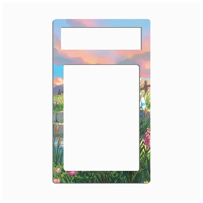 A decorative rectangular card or label with rounded corners, featuring a colorful illustrated border of grass, flowers, and a pastel sky. The top section has a smaller blank white rectangle, and the center is a larger blank white rectangle.