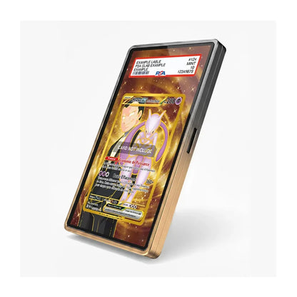 A black smartphone with a gold-toned bumper frame, shown at an angle on a light gray background. The screen displays a holographic Pokémon trading card insert with a red PSA authentication label at the top.