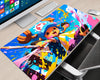 Tony Tony Chopper One Piece extended gaming mouse pad featuring Chopper in his blue hat with a pink cross emblem, surrounded by vibrant blue, pink, yellow, and white paint splashes on a gaming desk.