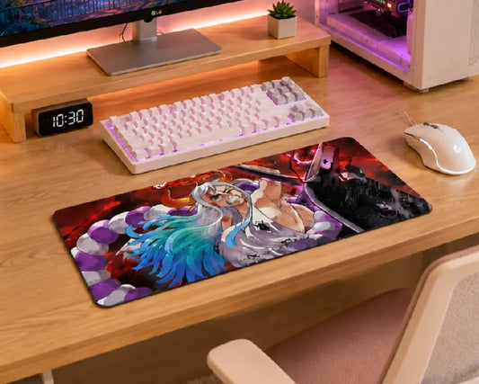 A large rectangular gaming desk mat with a colorful anime-style character print, shown on a light wood desk alongside a white mechanical keyboard, white mouse, and computer tower.