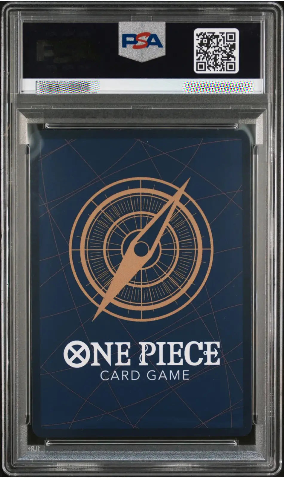 A PSA graded One Piece Card Game deck box inside a clear plastic grading case, featuring a dark blue cover with a gold compass design and white One Piece branding.