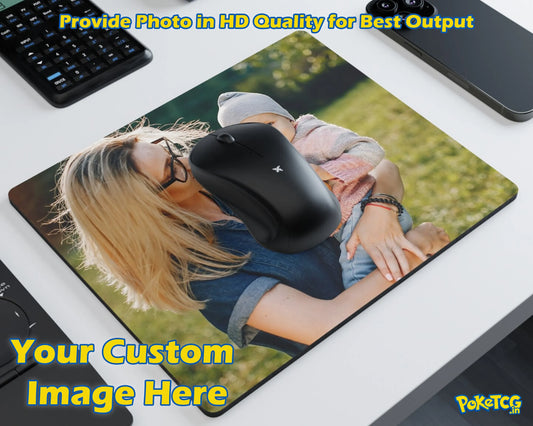A custom-printed rectangular desk mat or mouse pad shown on a white desk, featuring a printed photo of a woman holding a child outdoors. A black computer mouse is placed on top of the mat as a demonstration.