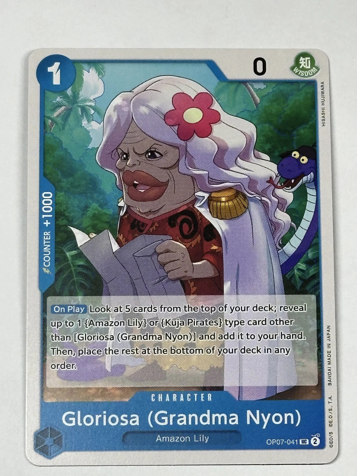 One Piece TCG character card OP07-041 featuring Gloriosa (Grandma Nyon) with grey hair and a pink flower, reading a newspaper with a purple snake in the background.