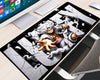 Extended One Piece gaming mouse pad featuring Monkey D. Luffy in Gear 5 form with flowing white hair, an outstretched hand, swirling white clouds, and cracked gray lettering against a black background, displayed on a light wood computer desk with a white keyboard, monitor, and white mouse.