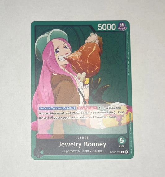 One Piece TCG leader card OP07-019 featuring Jewelry Bonney with pink hair eating a large piece of meat, wearing a green hat and brown jacket against a green background.