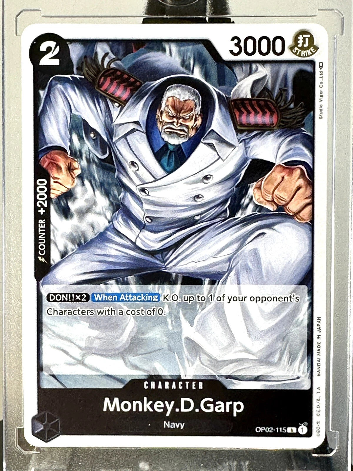 One Piece TCG Monkey D. Garp OP02-115 rare holographic card from Paramount War set featuring the legendary Marine hero in a premium foil finish.