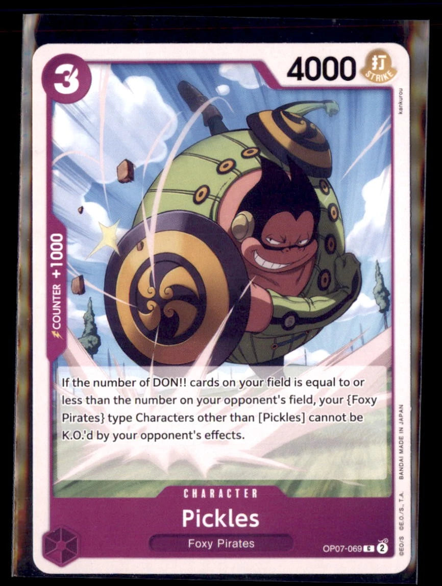 One Piece TCG character card OP07-069 featuring Pickles, a large man in a green padded suit with shields on his arms, lunging forward against a blue sky background