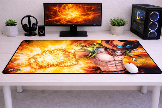 Large 24x12 inch One Piece mousepad featuring Portgas D. Ace unleashing a fiery orange flame attack on a clean gaming desk setup.